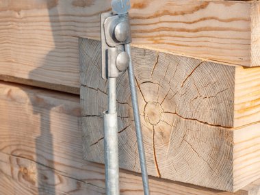 Yıldırım iletkeninin ayrıntıları, aydınlık ladin odunundan kare kirişlerden ev duvarına tel yıldırım iletkeni.