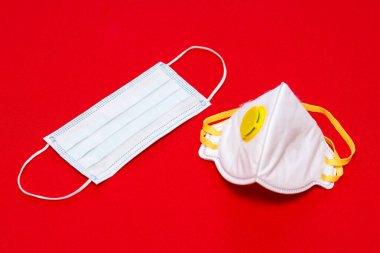 Coronavirus - 2019-nCoV, virüs konsepti. Cerrahi maske ve koruyucu maske. Kırmızı arkaplan. Uzayı kopyala, taklit et..