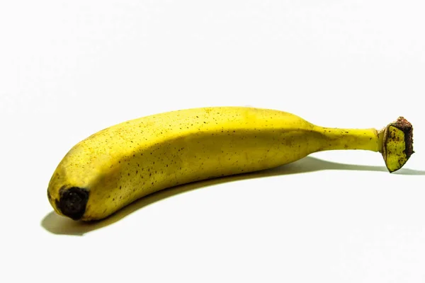 Single banana against white background, real banana — Stockfoto