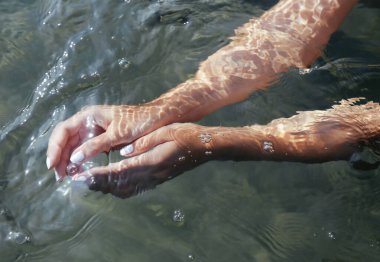 Sudaki bir kızın elleri. Sessiz renkler