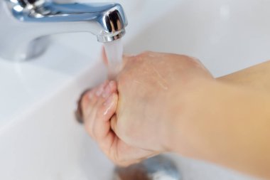 Bir kızın ellerinde sabun. El yıkama.