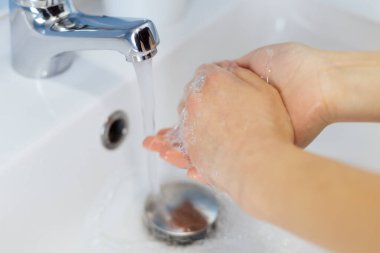 Bir kızın ellerinde sabun. El yıkama.