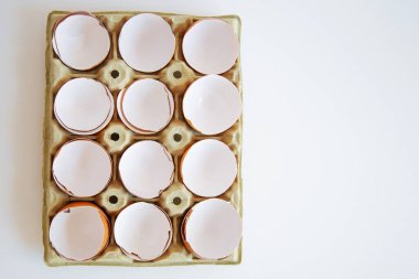 Karton tepside yumurtalar. Kutuda yumurta kabuğu. Yumurta kutusunda kırılmış yumurta kabuğu. 