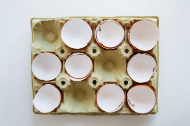 Karton tepside yumurtalar. Kutuda yumurta kabuğu. Yumurta kutusunda kırılmış yumurta kabuğu. 