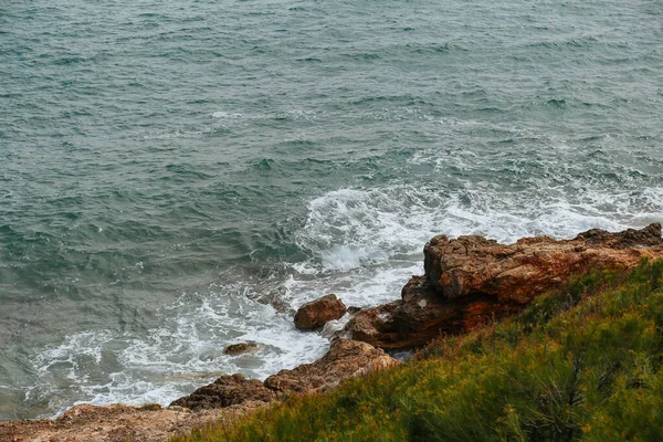 Coast. Sea and rocks. Blue surface and rocks. The light in the ocean.