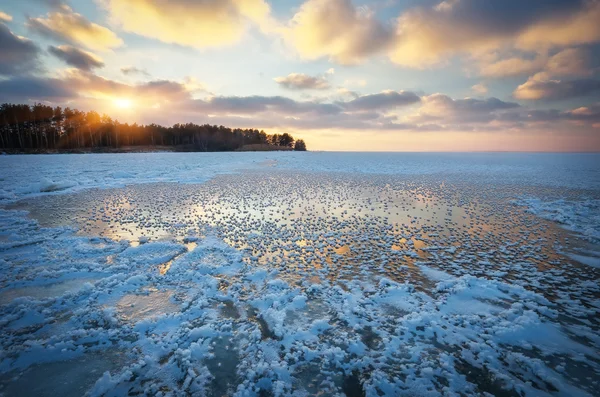 Зимний пейзаж с закатным небом и замерзшим озером — стоковое фото