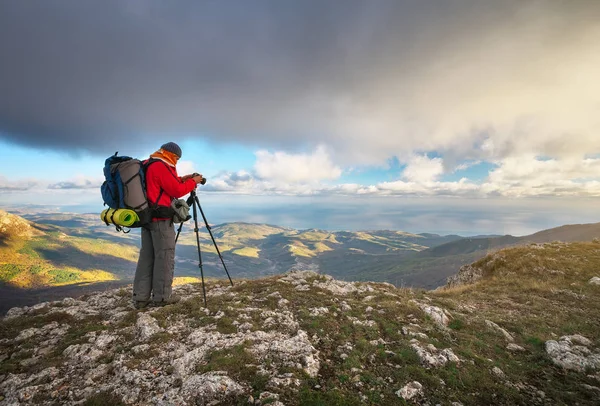 Fotógrafo toma fotos en la cima de la montaña en otoño . — Foto de Stock