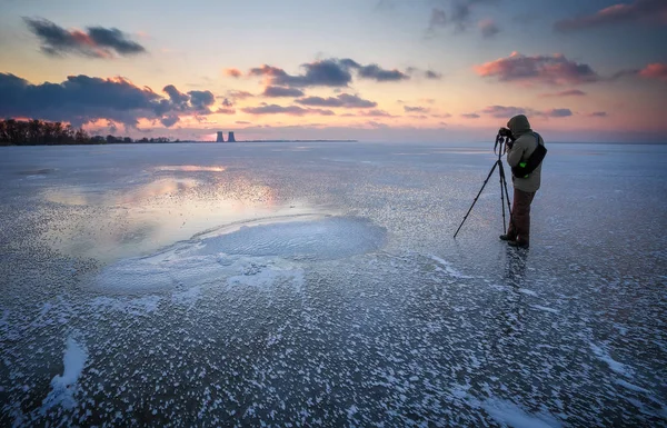 Photographer takes a picture of sunset on a frozen river in winter — Stock Photo, Image