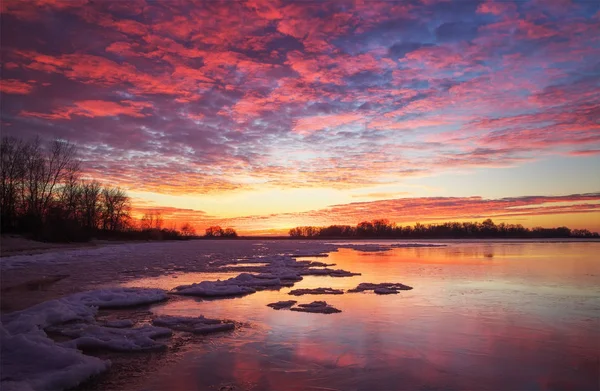 Beautiful winter landscape with sunset fiery sky and frozen lake — Stock Photo, Image