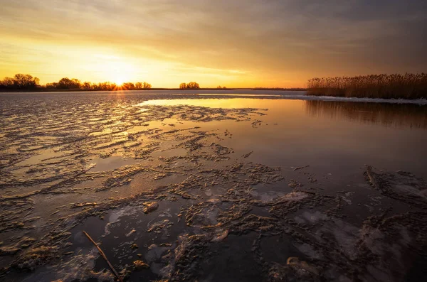 Zimní krajina s řekou, rákosí a západem slunce obloha. — Stock fotografie