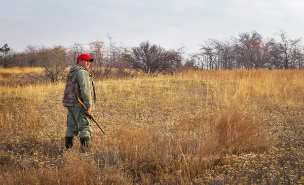 Hunter se mueve con una escopeta en busca de presas —  Fotos de Stock