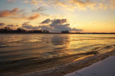 Donmuş Göl ve Günbatımlı Gökyüzü ile Kış Manzarası. 