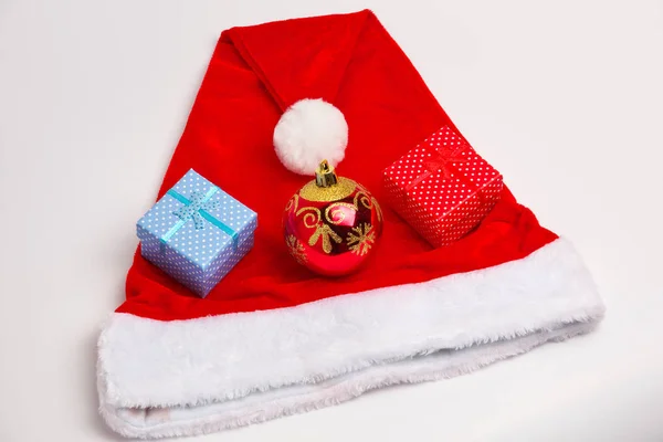 Noel Baba kırmızı ve beyaz şapka, oyuncak kabarcıklar ve Noel hediyeleri — Stok fotoğraf