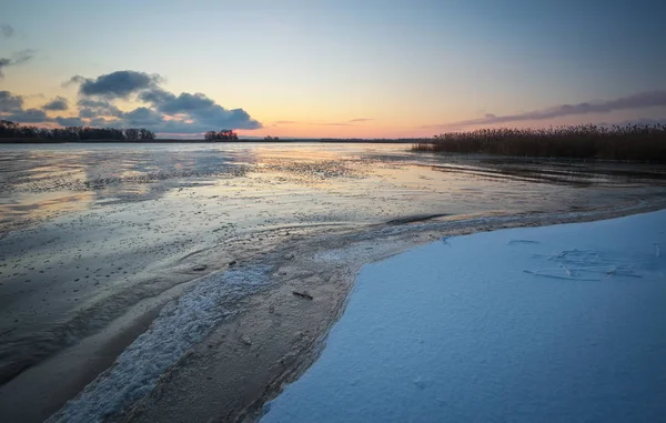 Paesaggio invernale con lago ghiacciato e cielo al tramonto. — Foto Stock