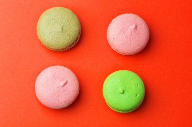 Tasty farklı macaroons kırmızı arka plan üzerinde renkli