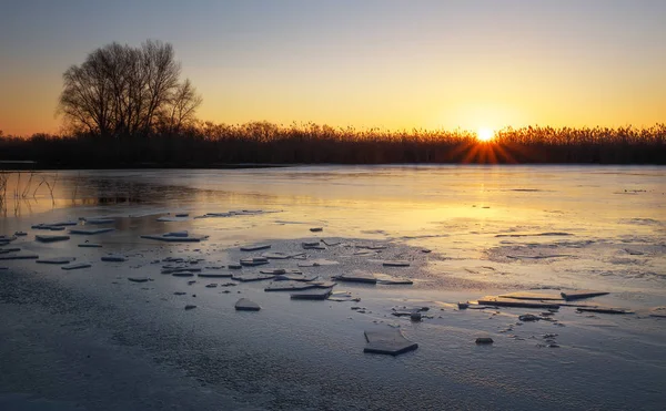 Zimní krajina s západu slunce na obloze a zamrzlou řeku. Za úsvitu — Stock fotografie