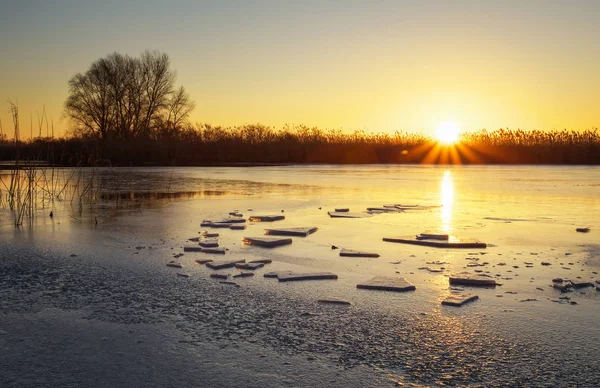 Winterlandschaft mit Sonnenuntergang und gefrorenem Fluss. — Stockfoto