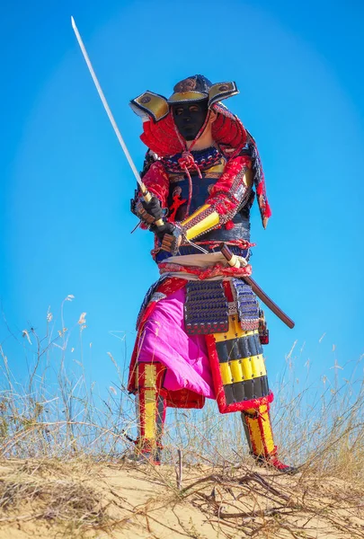 Самурай с мечом на песке. Люди в самурайских доспехах на песке — стоковое фото