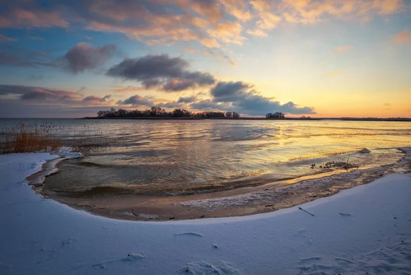 Donmuş Göl ve Günbatımlı Gökyüzü ile Kış Manzarası.