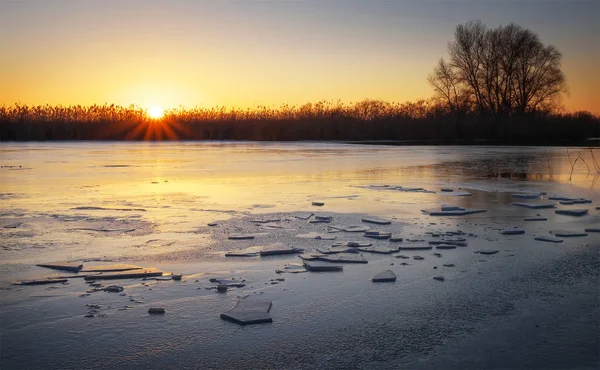Zimní krajina s západu slunce na obloze a zamrzlou řeku. — Stock fotografie