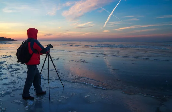 Fotograf ta bilder på frusna floden under solnedgången — Stockfoto