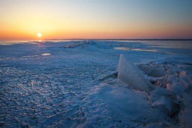 Donmuş Göl ve Günbatımlı Gökyüzü ile Kış Manzarası.
