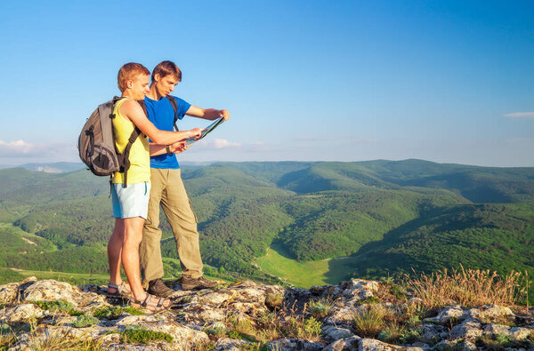 Два туриста на горе прочли карту. Мужчины на вершине скалы
. 