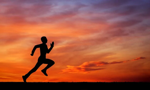 Silhouette of running man on sunset fiery sky background — Stock Photo, Image