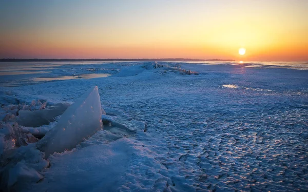 Zimní krajina se zamrzlým jezerem a zapadajícím nebem. — Stock fotografie