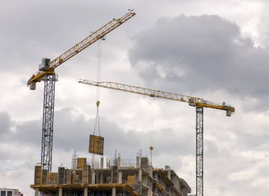 Vinç ile çok katlı binaların inşaat. İşçi iş 