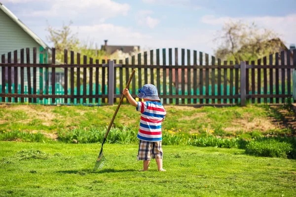 2 歳くらいの小さな男の子が庭で作業. — ストック写真