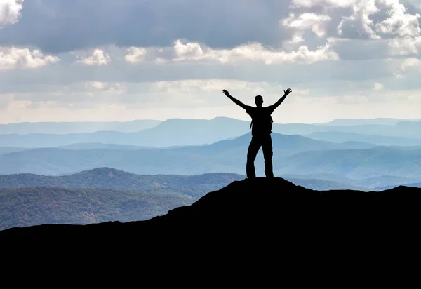 La silueta de un hombre en la cima de una montaña. Persona en la roca . — Foto de Stock