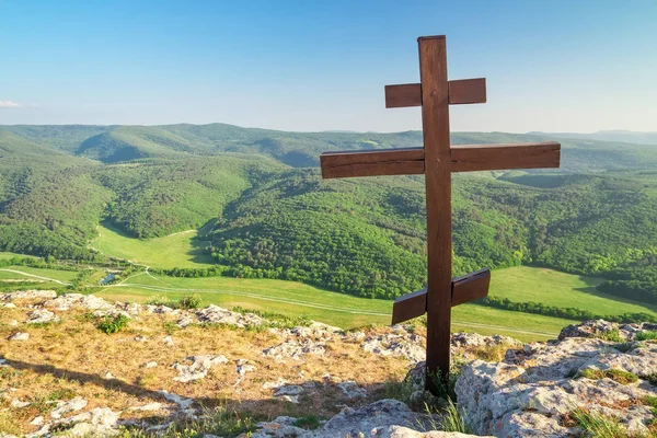 Orthodox cross on top of a mountain. Spring landscape