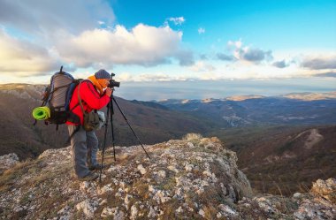 Fotoğrafçı fotoğraf dağın zirvesinde sonbaharda çeker. 