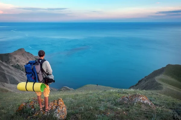 Молодий турист на вершині гори насолоджується видом на море . — стокове фото