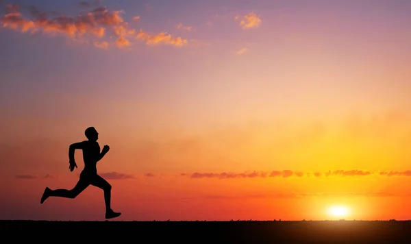 Lopende man silhouet zonsondergang tijdig. — Stockfoto