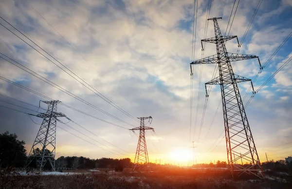 High-voltage power lines during fiery sunrise — Stock Photo, Image