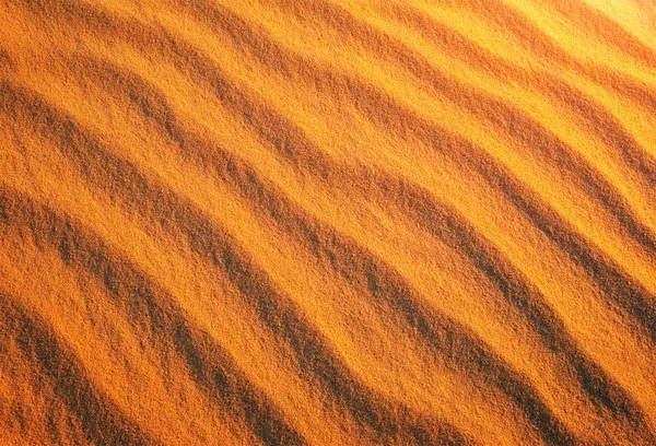 Areia dourada do deserto durante o pôr do sol como fundo — Fotografia de Stock