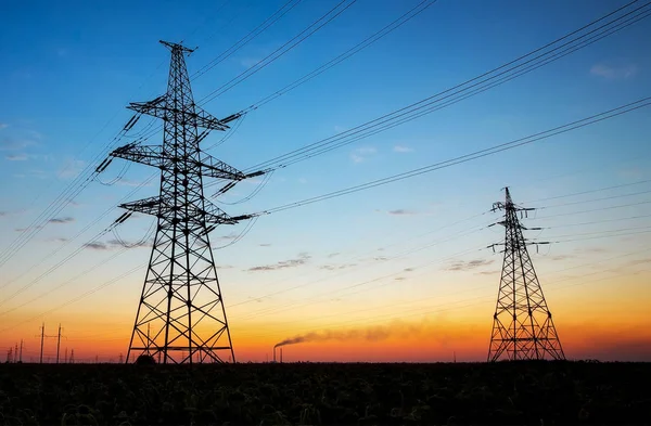 Silhouette of electricity pylons and high-voltage power lines on — Stock Photo, Image