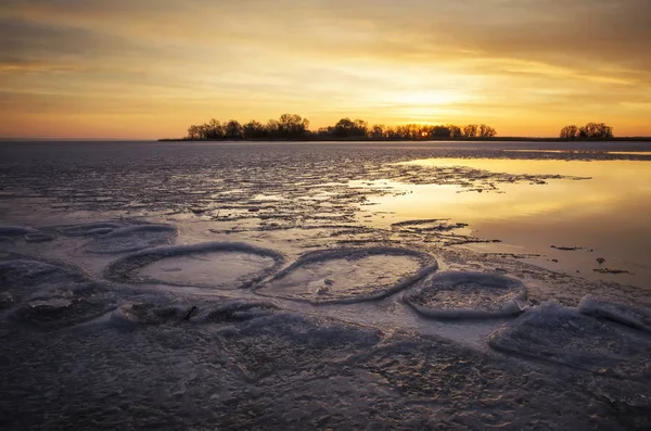 Hermoso paisaje de invierno con río congelado, cañas y cielo al atardecer — Foto de Stock
