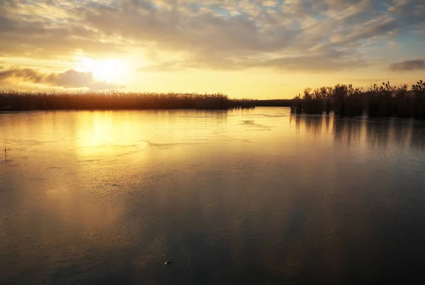 Paysage hivernal avec rivière gelée et ciel couchant . — Photo