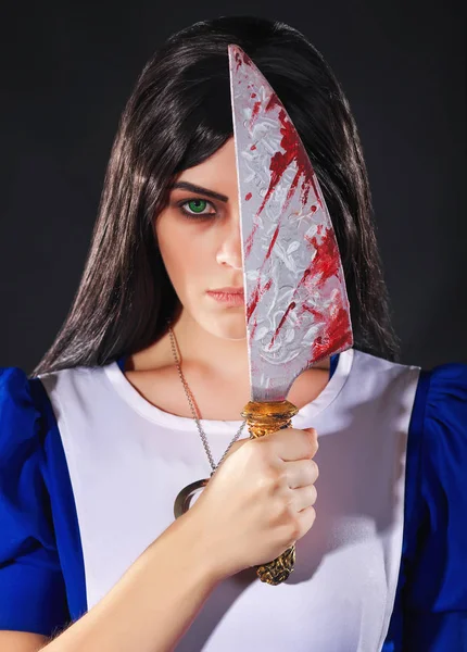 Portrait d'une jeune femme avec un couteau habillé comme Alice au Merveille — Photo