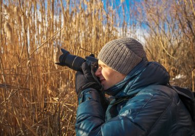 Portre fotoğrafçısı ile dijital fotoğraf makinesi açık havada. Genç adam 
