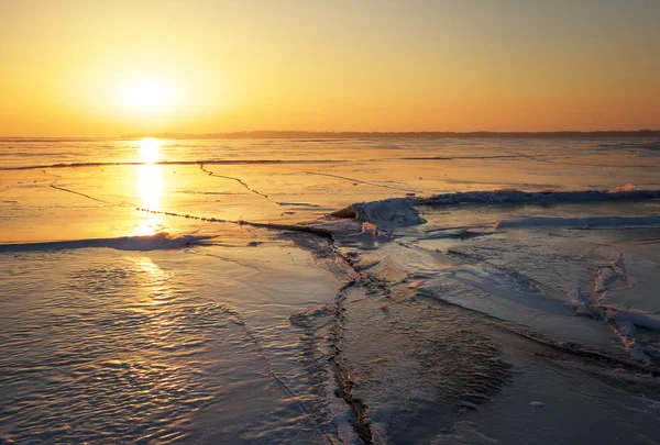 Paisaje invernal con grietas en el lago congelado cerca de la orilla a — Foto de Stock