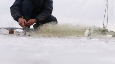 Fishermens donmuş bir havuzda delikten balık çekin. Balık tutma kış
