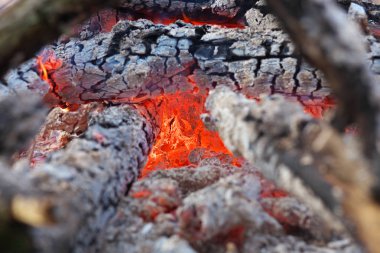 Bir şenlik ateşi içinde şömine alevleri ateş. Kömürlerin yakın çekim.