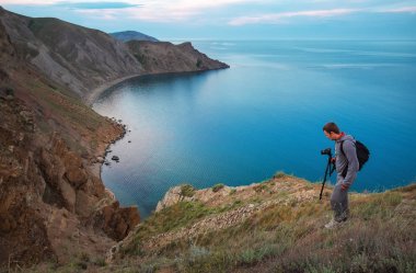 Bir fotoğrafçı bir tripod ve kamera ile landscap fotoğraflarını yapar