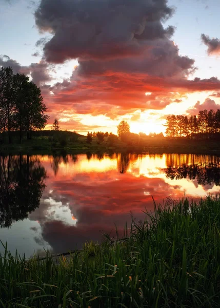 Wunderschöne Landschaft mit feurigem Sonnenuntergang über dem See. — Stockfoto