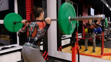Genç adam crouches ve fitness merkezinde spor salonunda bir çizgiyle yükselir
