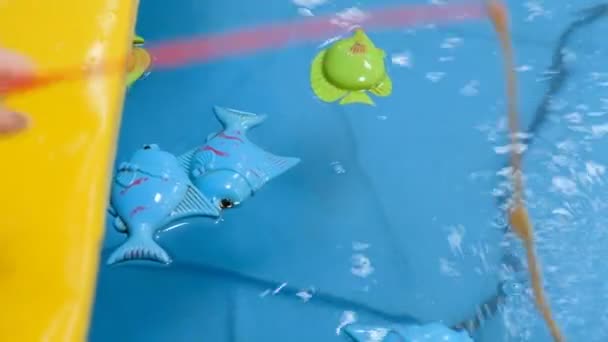 Het Kind Vangsten Toy Vis Het Water Met Een Hengel — Stockvideo